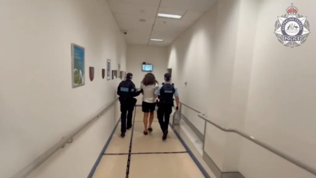 A man is escorted by two police officers.