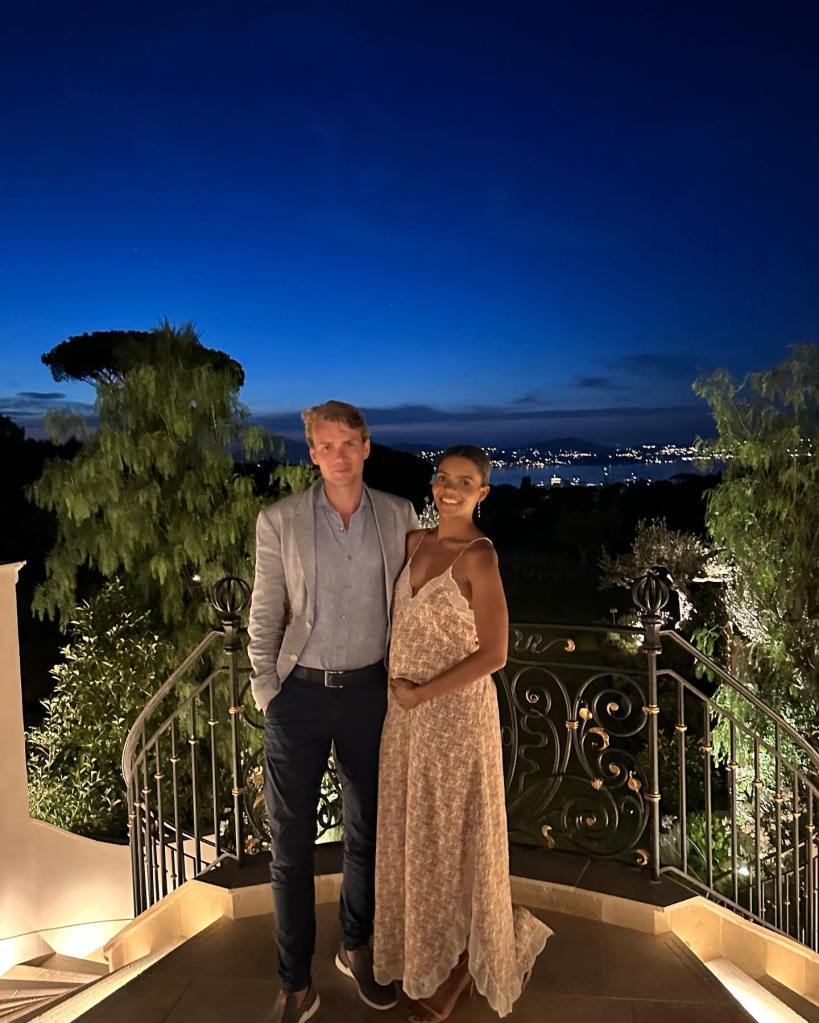 Candace Owens and George Farmer pose on a balcony at night.