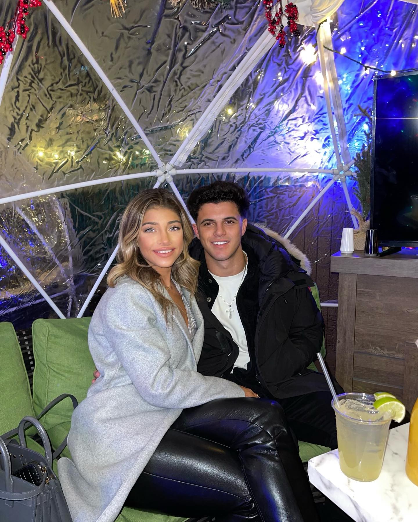 Gia Giudice and boyfriend Christian Carmichael sitting in an outdoor igloo-like structure.
