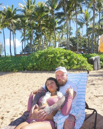 Teddy Swims and Raiche Wright at a beach, with Wright's pregnant belly visible.