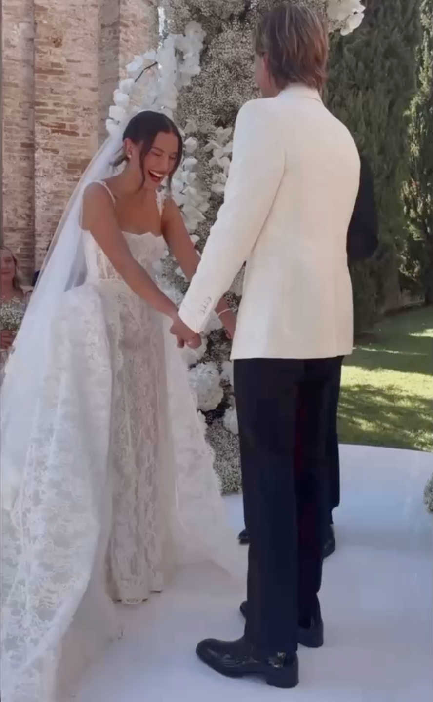 Millie Bobby Brown and Jake Bongiovi holding hands at their wedding ceremony.