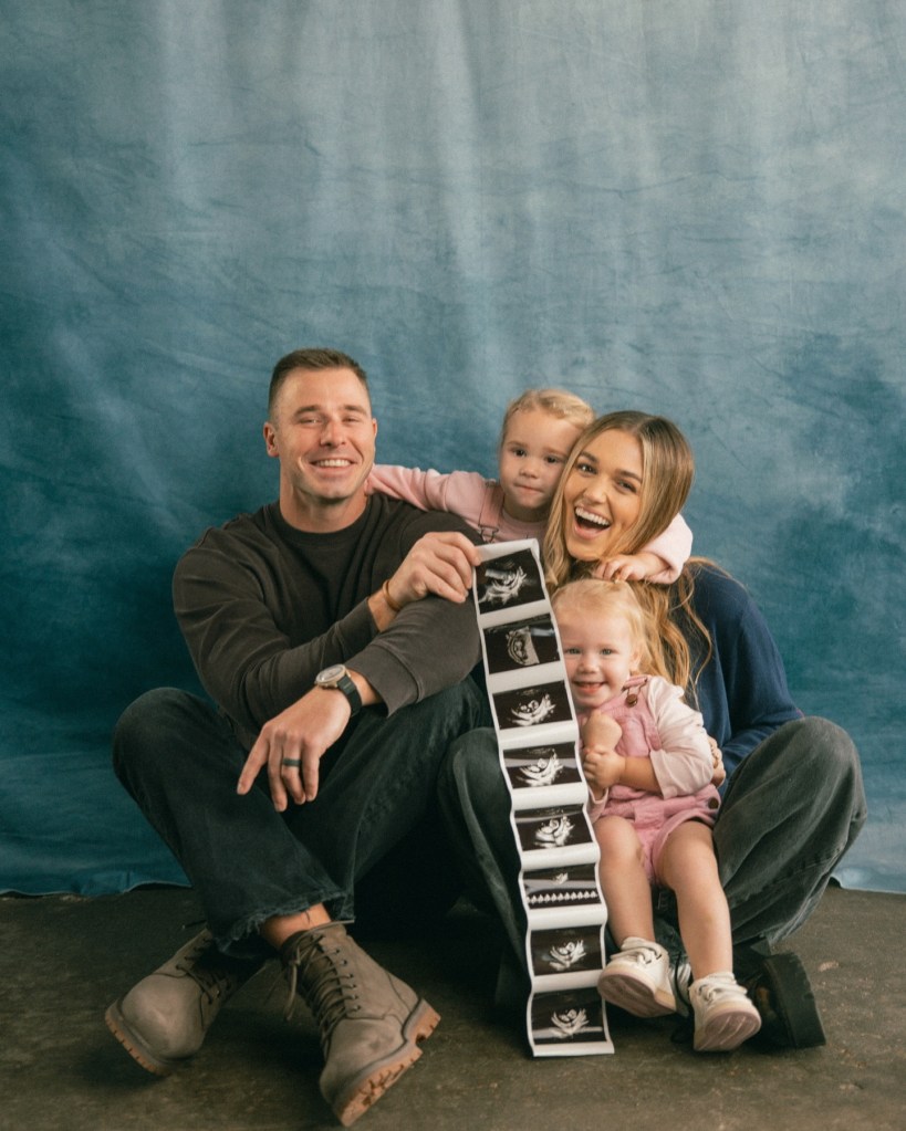 Sadie Robertson and Christian Huff with their two daughters, holding a strip of ultrasound images for their third child.