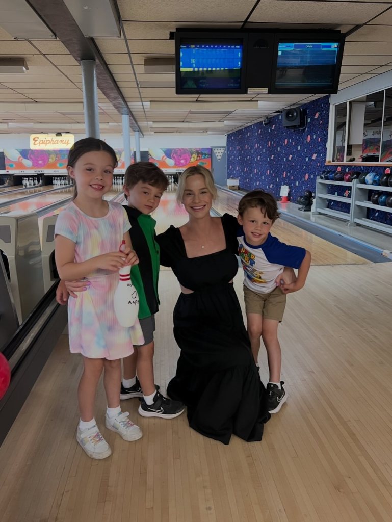 Meghan King poses with her three children in a bowling alley.