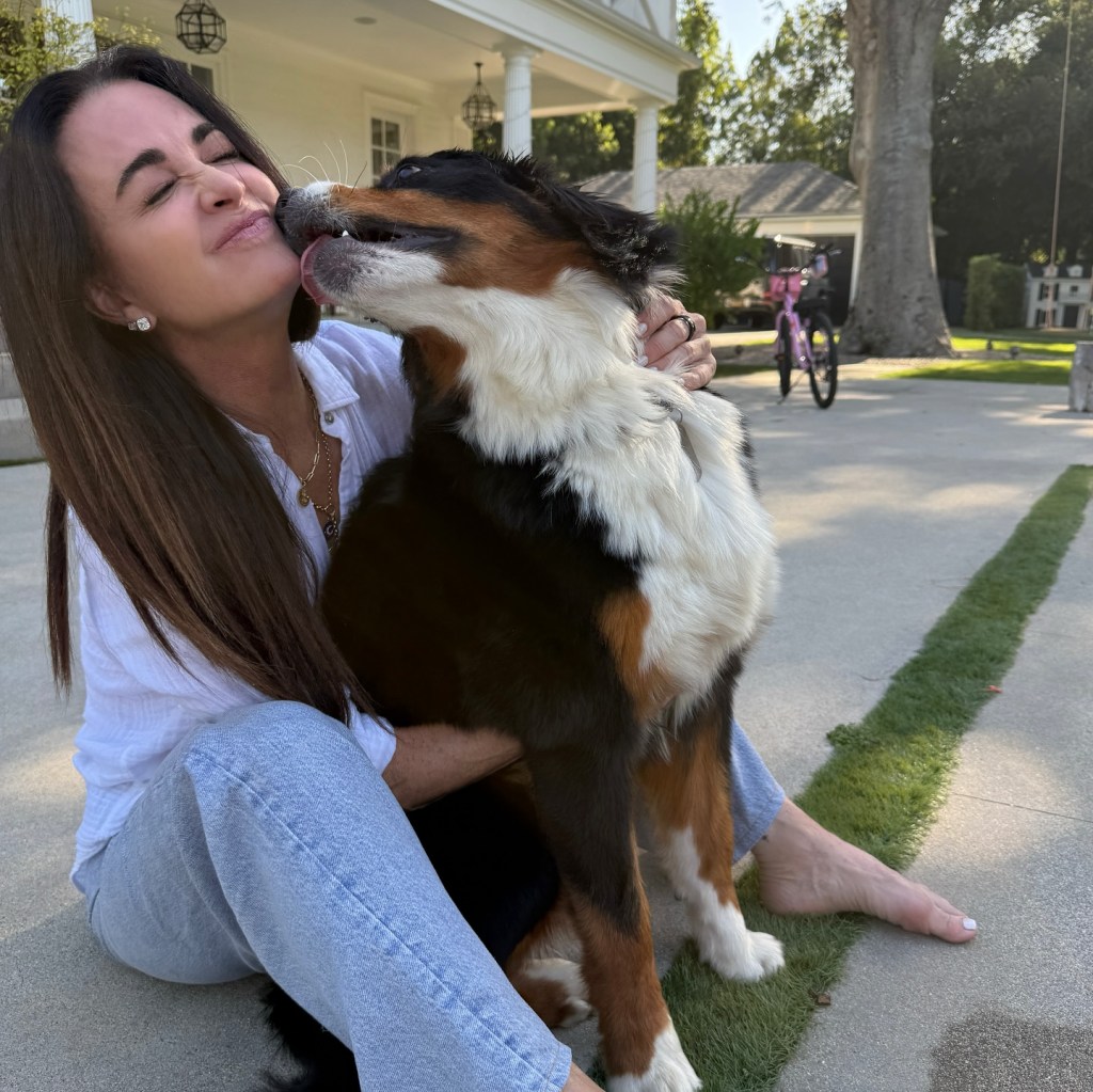 Kyle Richards with a puppy licking her face.