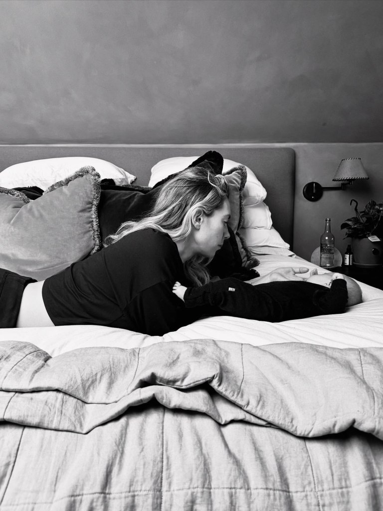 Vanessa Kirby and Paul Rabil on the bed with their newborn baby.