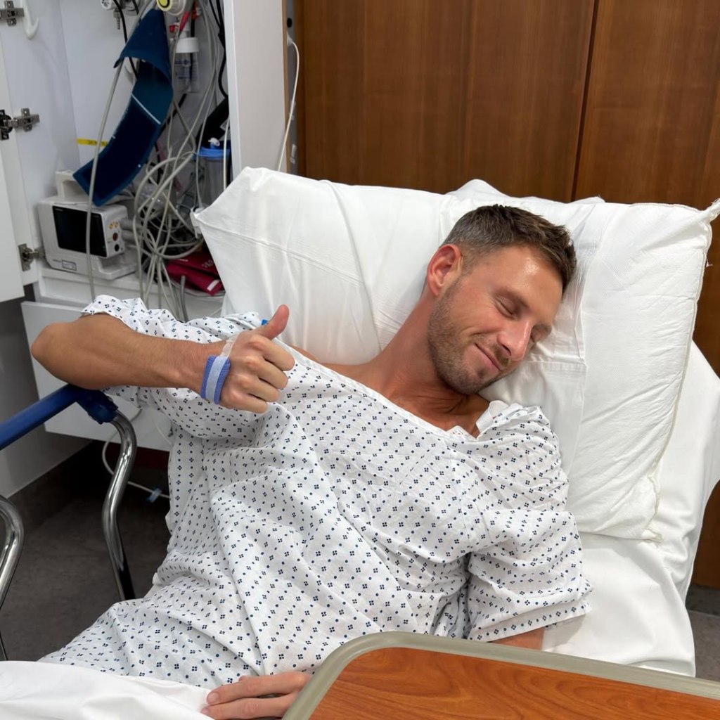 Fraser Olender giving a thumbs up from a hospital bed.