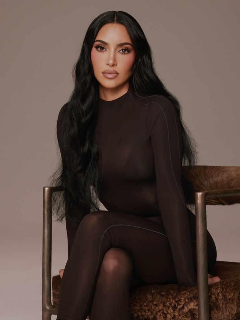 Kim Kardashian in a black long-sleeved bodysuit.