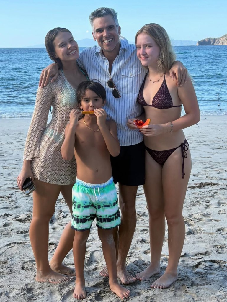 Cash Warren with two young women and a young boy on a beach.