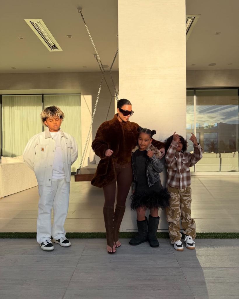 Kim Kardashian posing with North West, Saint West, and Chicago West.