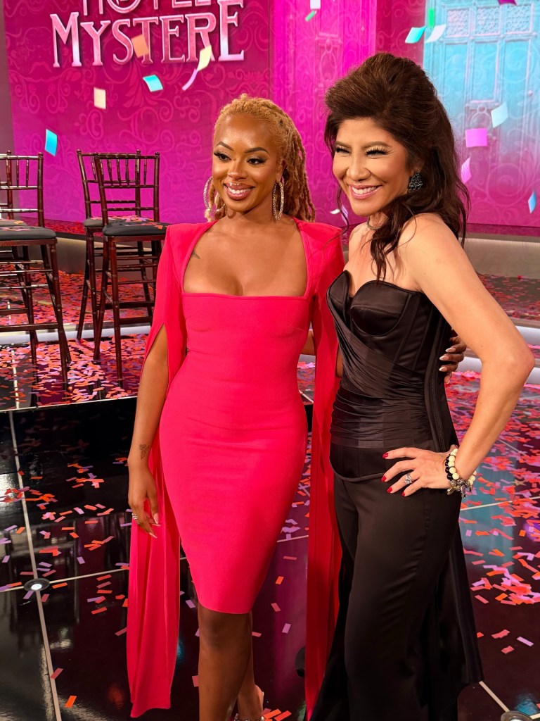 Julie Chen and Mickey Lee smiling on a stage with confetti.