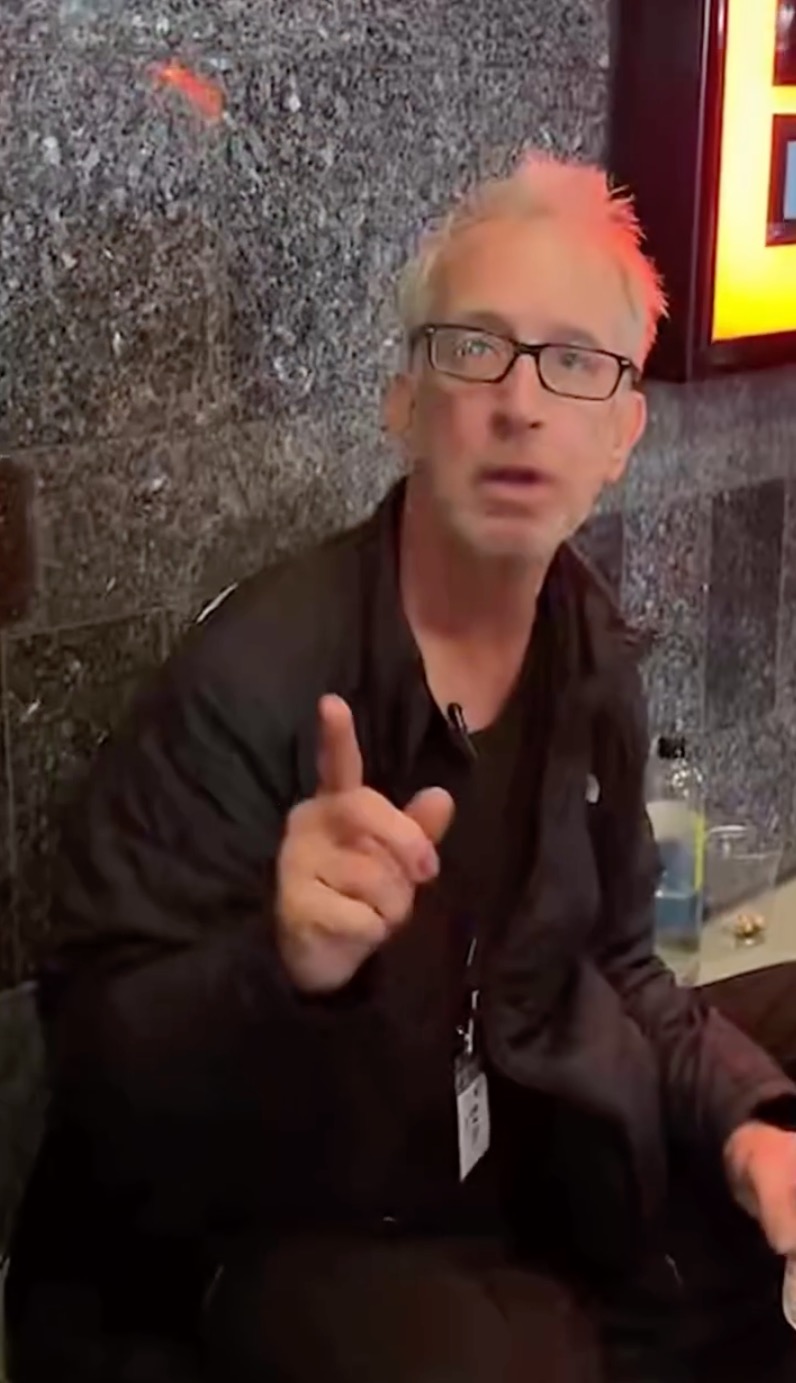Andy Dick sitting on the ground in downtown Los Angeles.