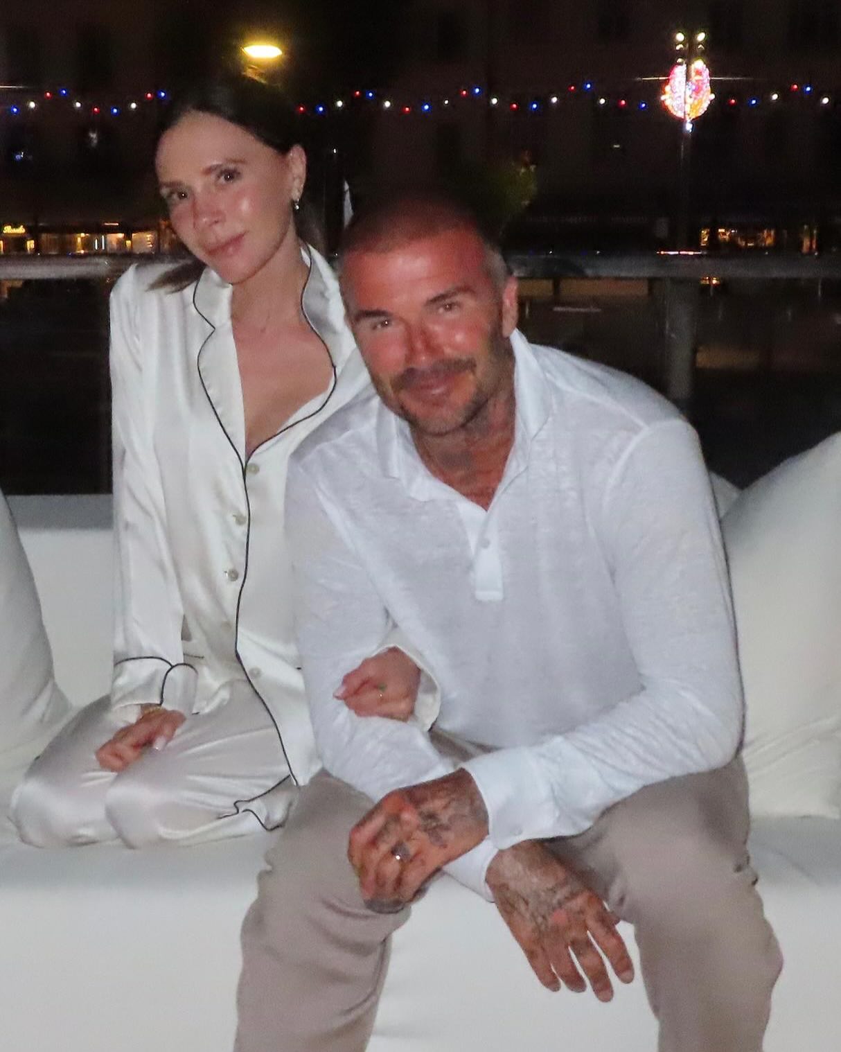 Victoria and David Beckham posing together at night.