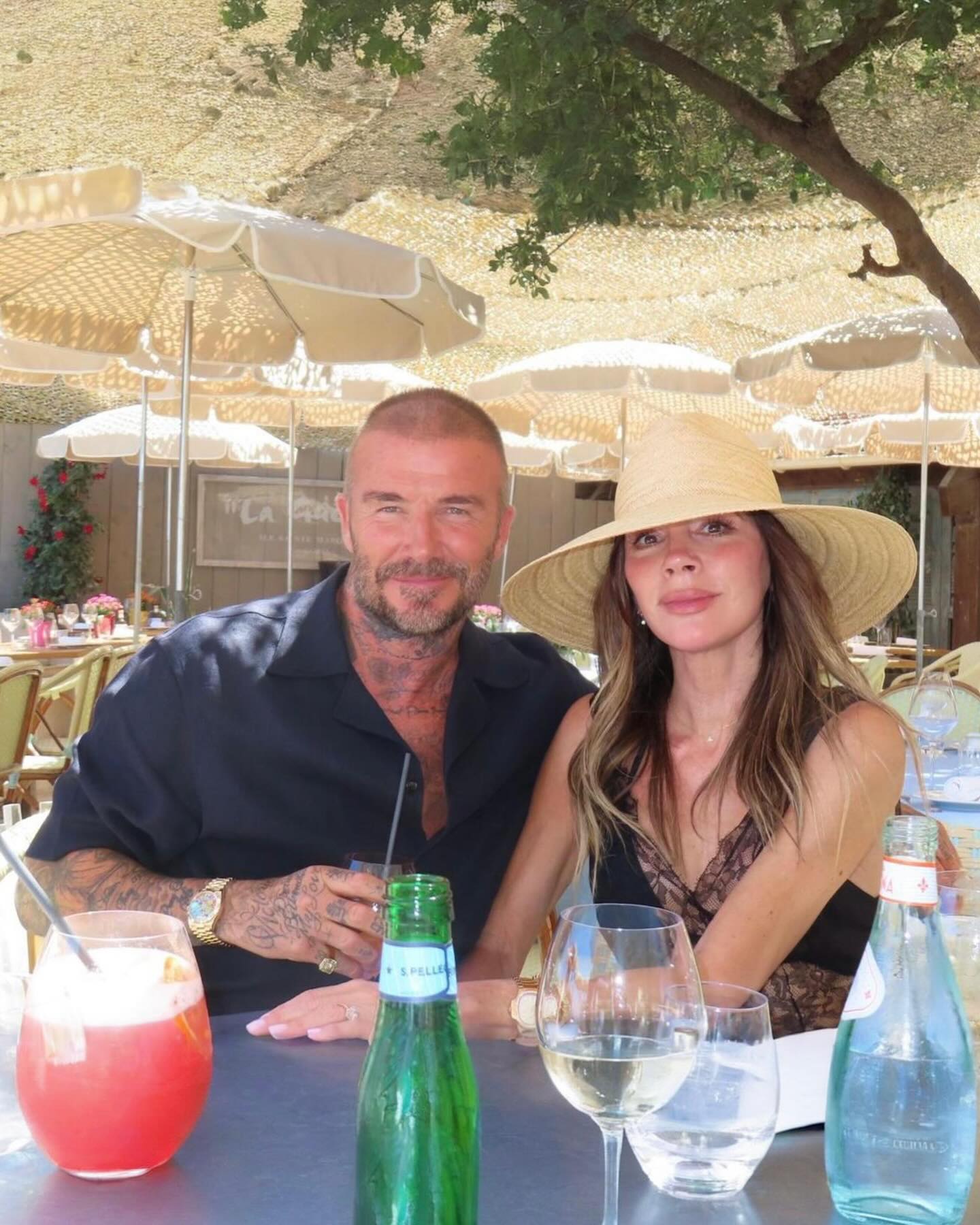 Victoria and David Beckham posing at an outdoor restaurant.