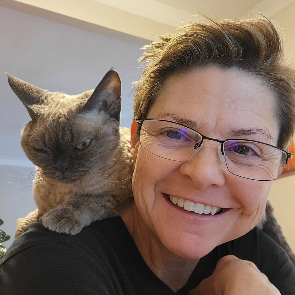 Wenne Alton Davis with a Devon Rex cat on her shoulder.