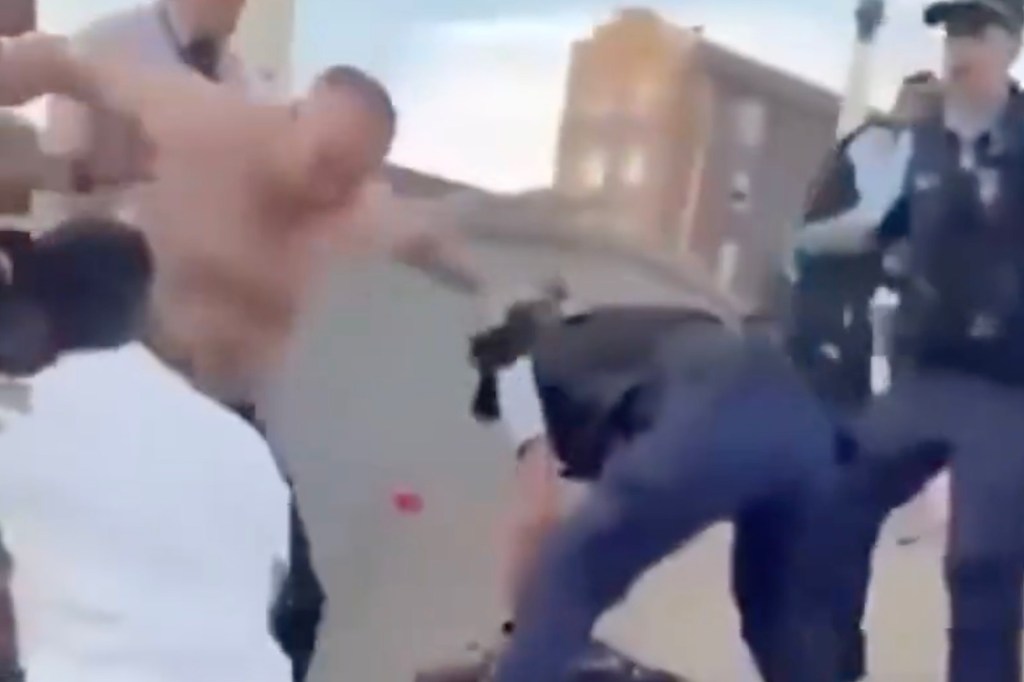 Multiple individuals involved in a physical altercation outdoors.