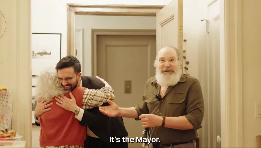 Mandy Patinkin gesturing as Zohran Mamdani hugs Patinkin's wife, Kathryn Grody.