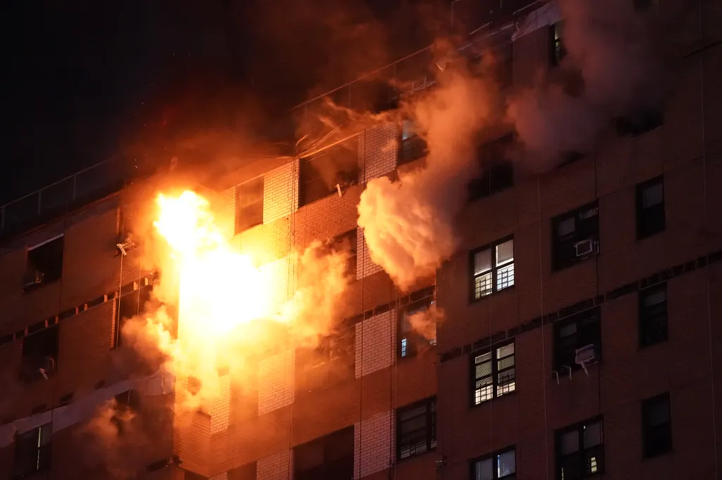 Flames and smoke erupting from a building at night.