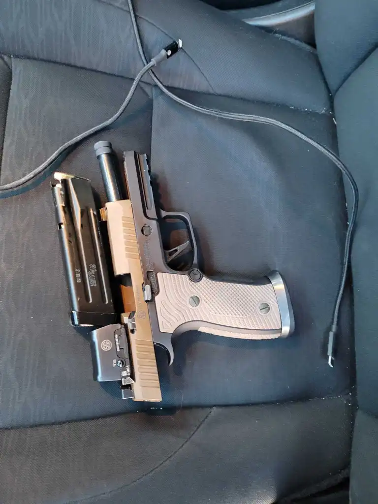 A semi-automatic handgun and magazine resting on a car seat.