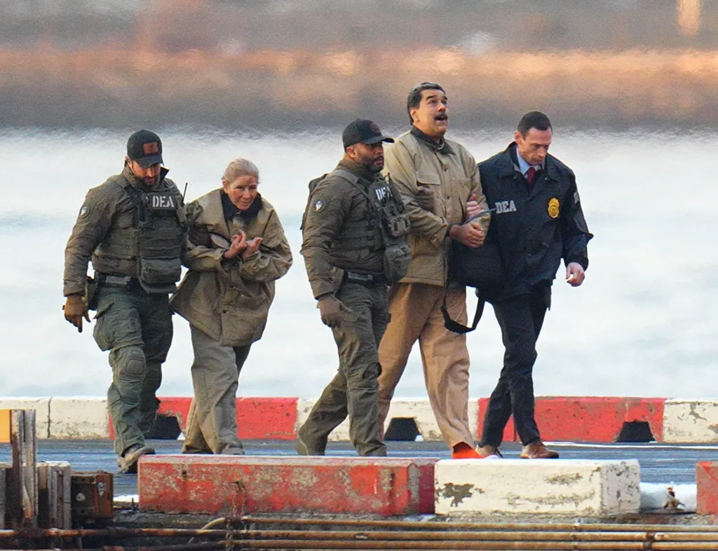Nicolas Maduro and his wife, Cilia Flores, are seen in handcuffs after landing at a Manhattan helipad, escorted by heavily armed Federal agents as they make their way into an armored car en route to a Federal courthouse in Manhattan on January 5, 2026 in New York City