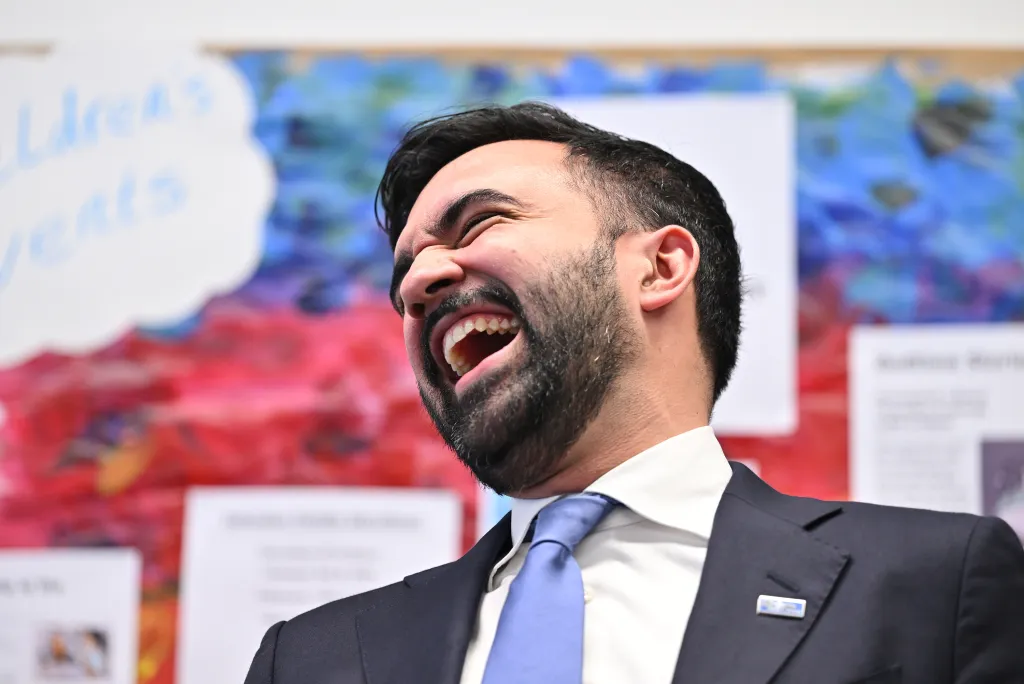 Mayor-elect Mamdani laughs with his head tilted back.