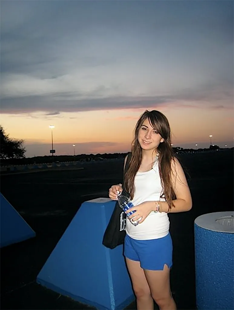 Victoria, daughter of Tommy Lee Jones, holding a water bottle with a sunset in the background.