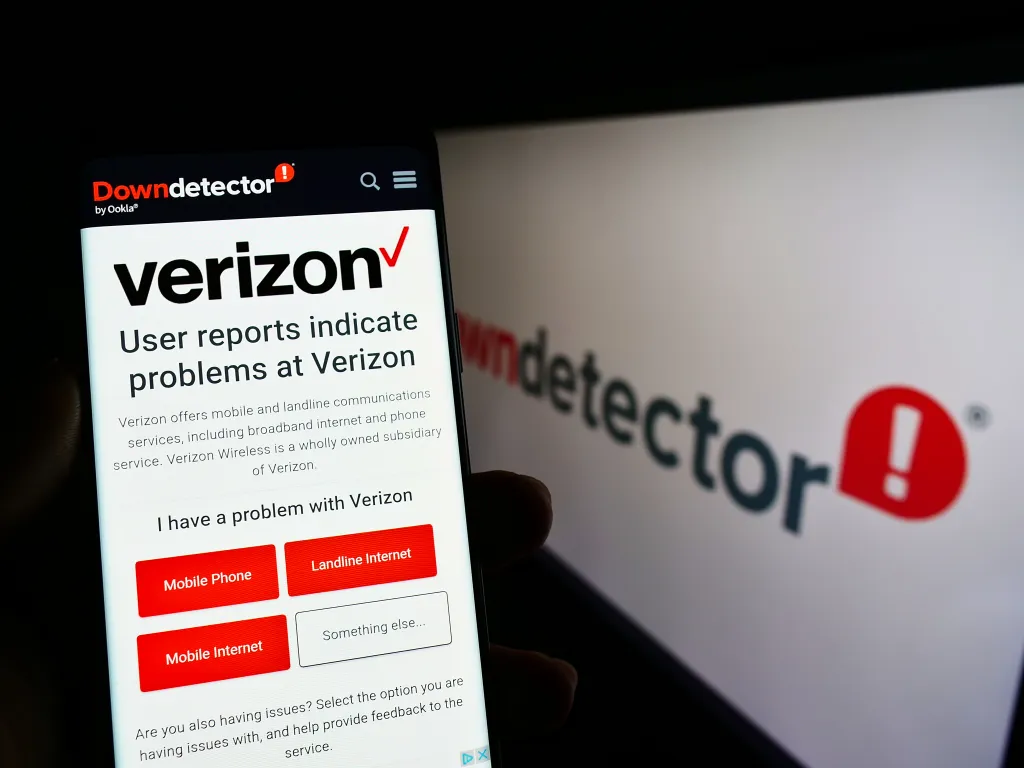 Smartphone displaying Downdetector website with Verizon outage status.