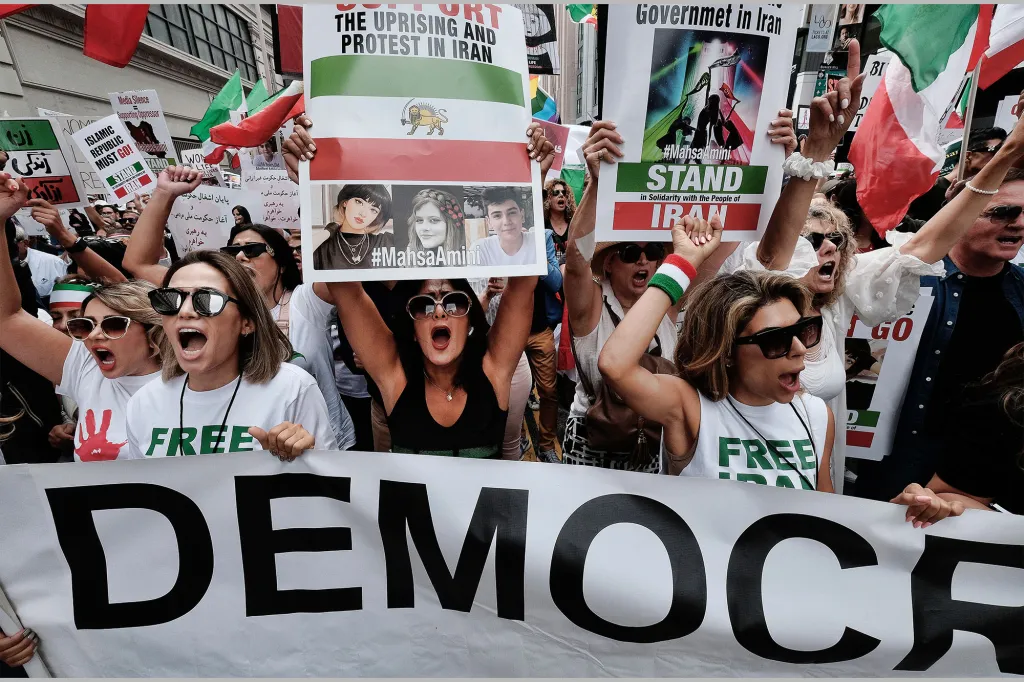 People protesting in the streets of New York, holding signs in support of Mahsa Amini, freedom, and democracy in Iran.