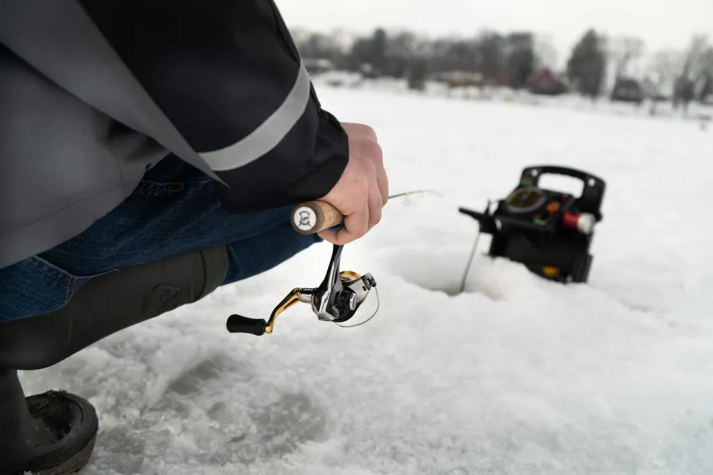 Person ice fishing with a depth finder.