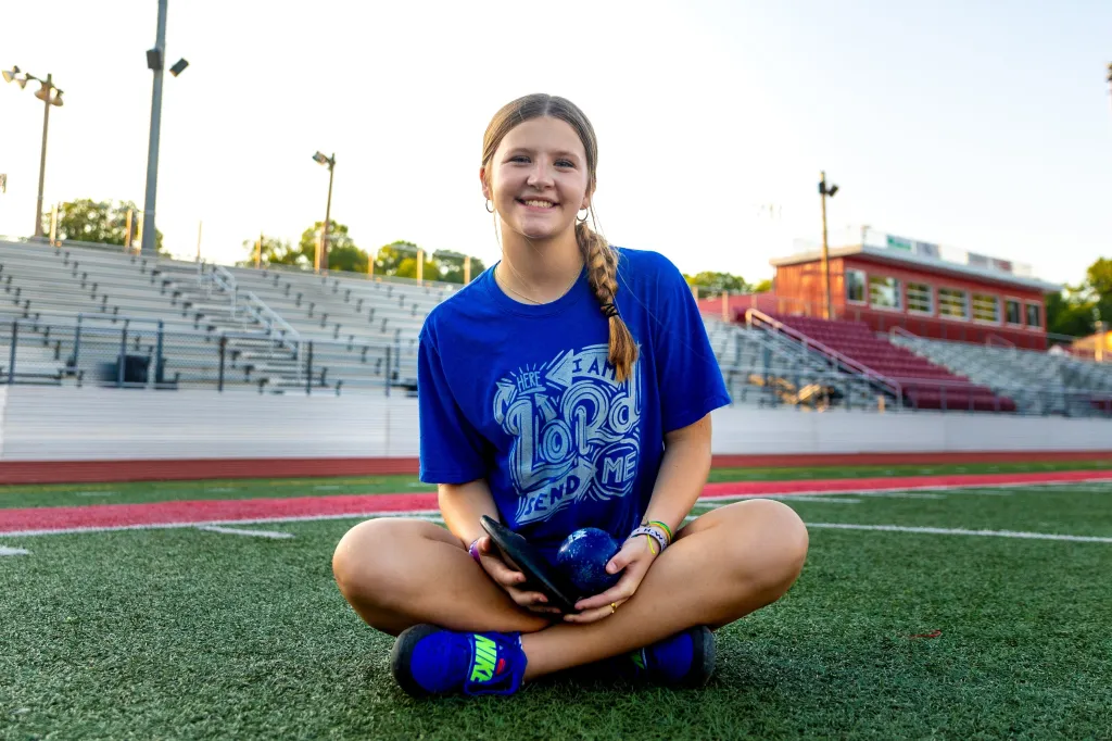 Adaleia Cross, a high school student, sitting on a football field.