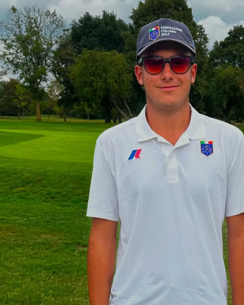 Emanuele Galeppini wearing sunglasses, a white polo shirt, and a hat with the 