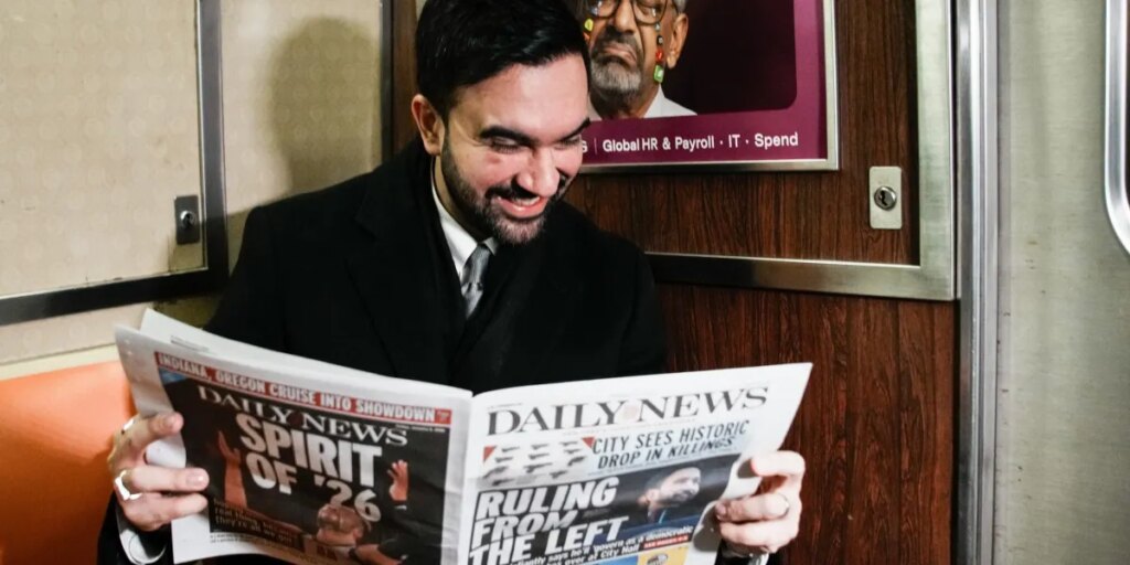 French tourists didn’t believe the young guy on the subway was New York City’s new mayor, so he held up the newspaper to prove it