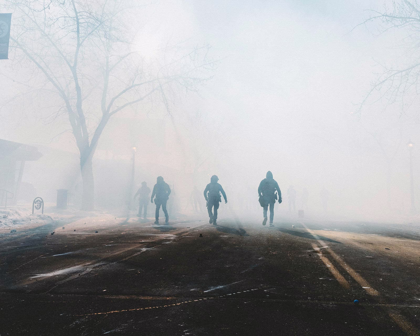 ICE officers are seen in the streets foggy with tear gas