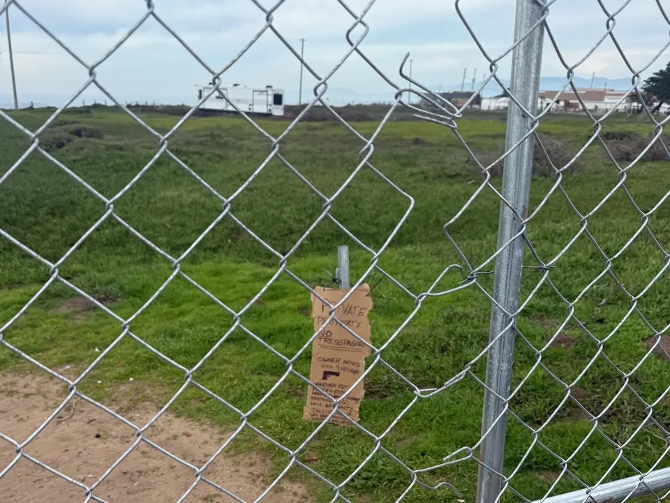 Chainlink fence blocking access to a grassy area with a 