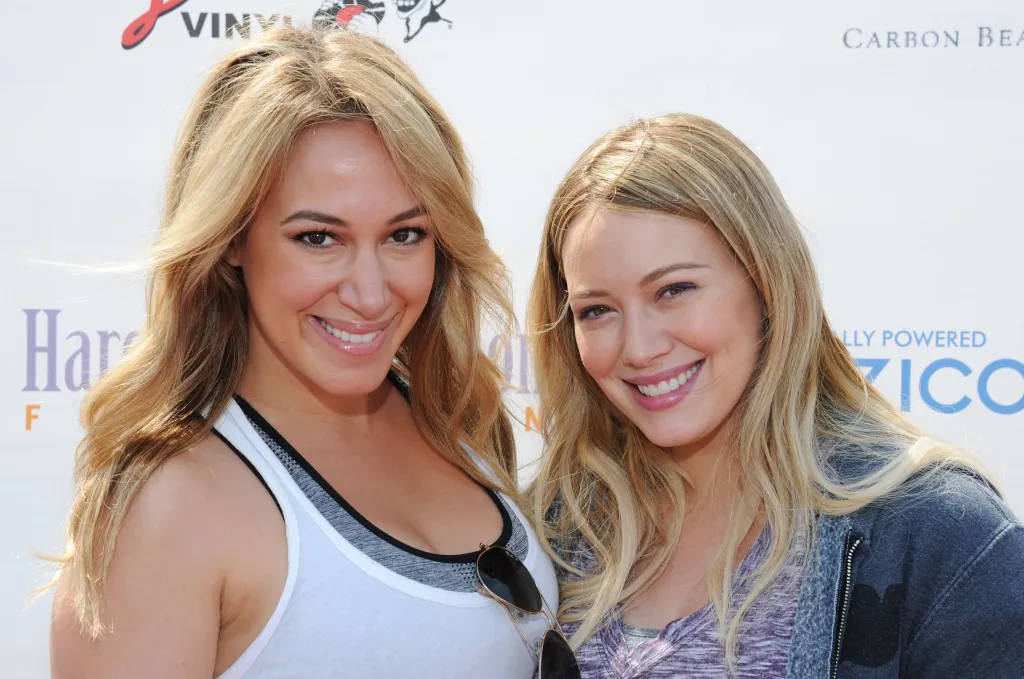 Haylie Duff and Hilary Duff smiling at The Harold Robinson Foundation's 2012 Pedal On The Pier Fundraiser.