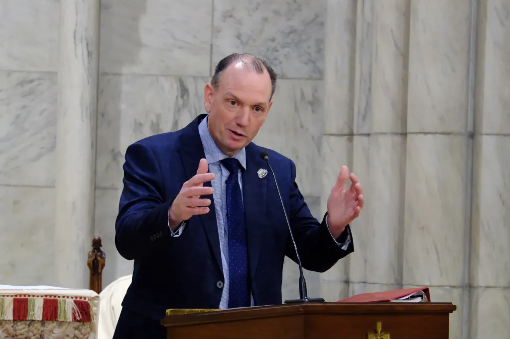 Police Benevolent Association President Patrick Hendry speaking at a podium.