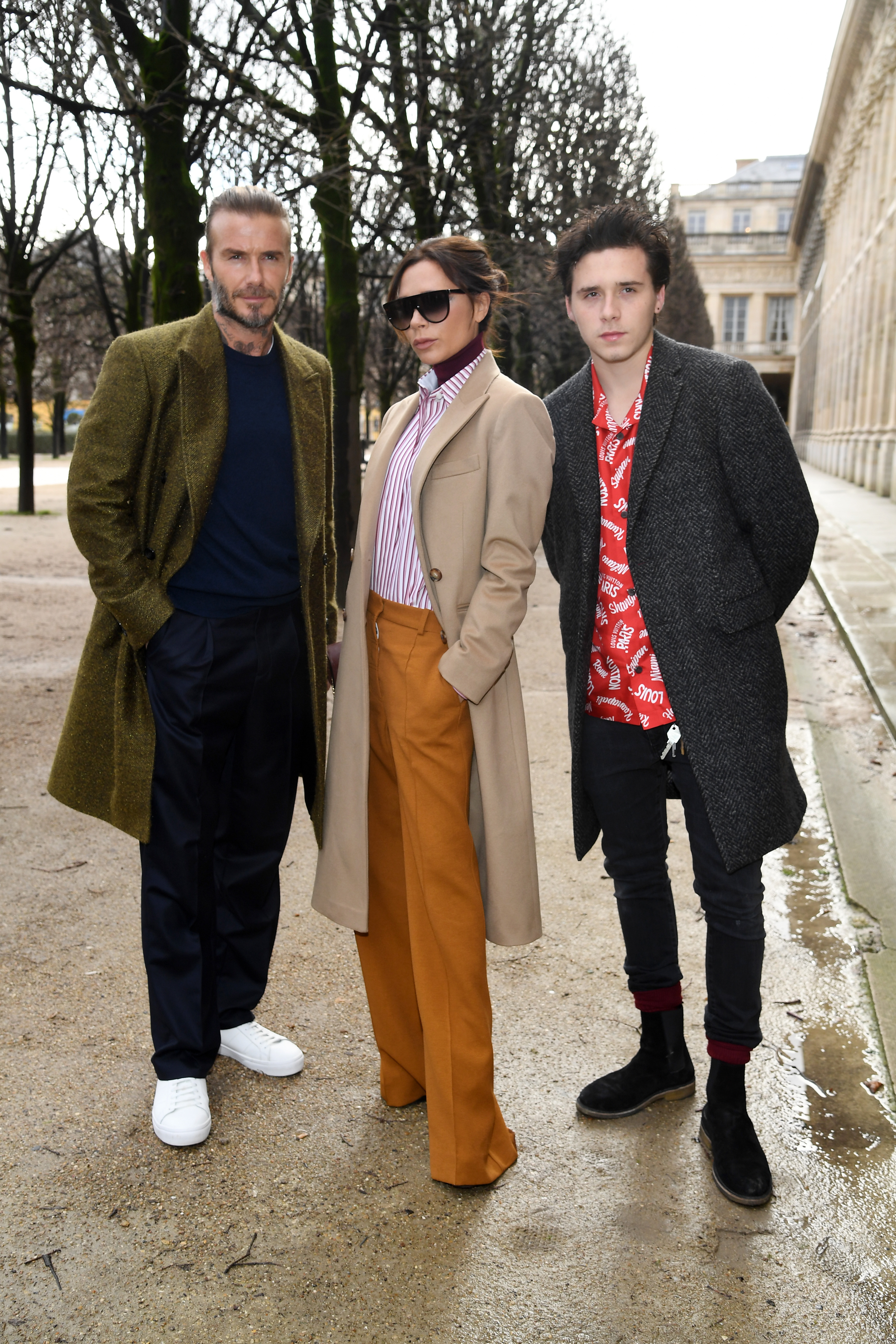 David Beckham, Victoria Beckham, and Brooklyn Beckham attend a fashion show in Paris.