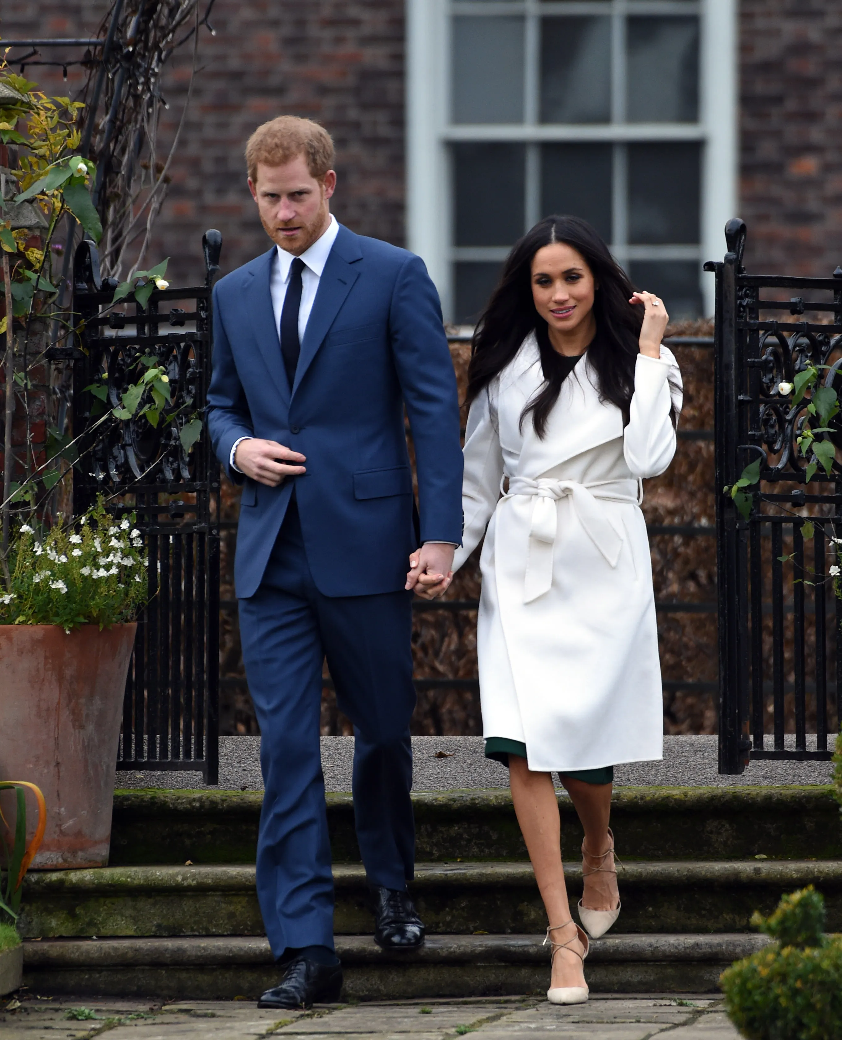 Prince Harry and Meghan Markle holding hands at their engagement photocall at Sunken Garden, Kensington Palace.