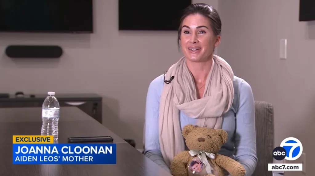 Joanna Cloonan, Aiden Leos' mother, holding a teddy bear with a photo of Aiden pinned to it.