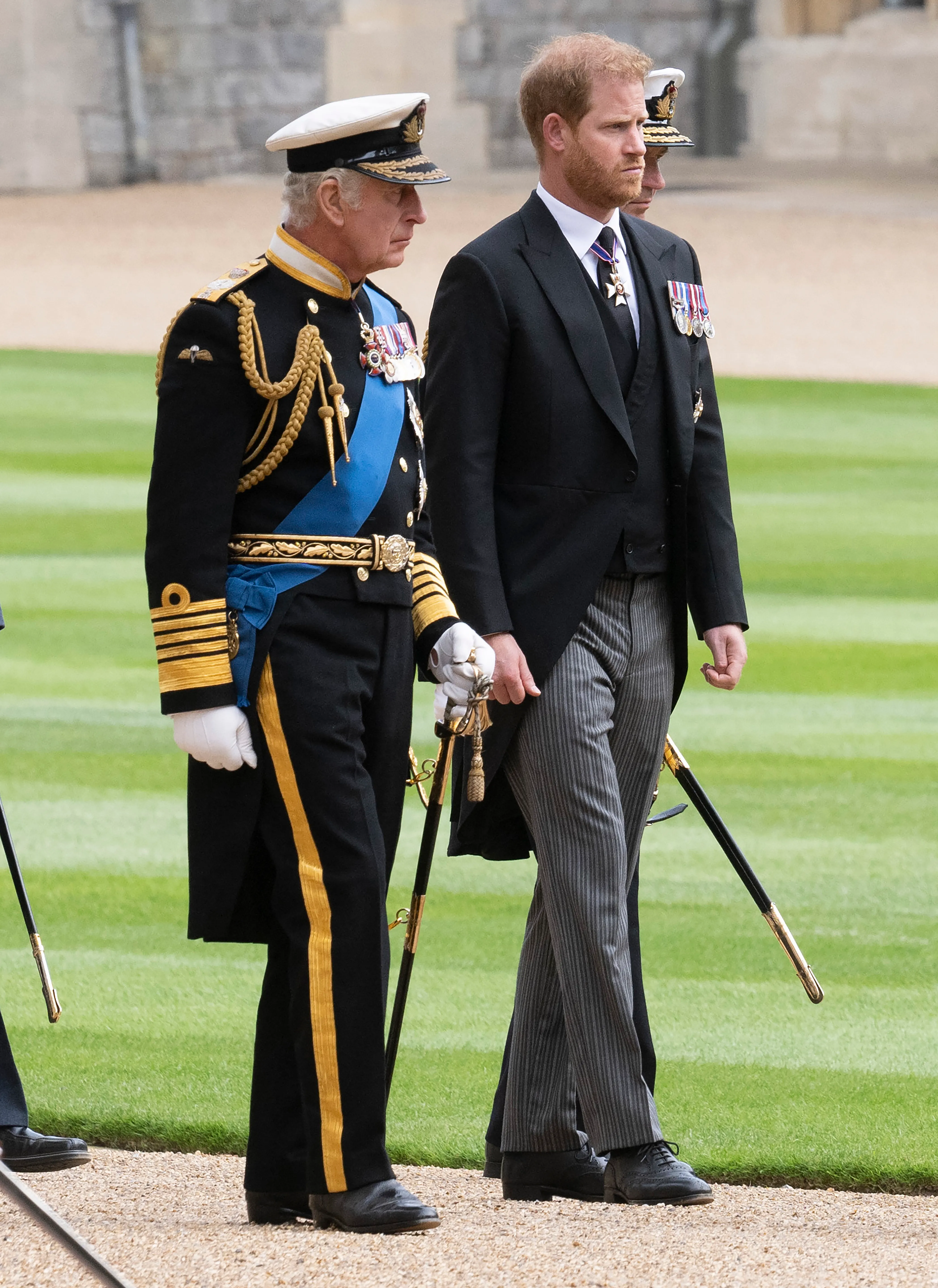 King Charles III and Prince Harry walking side-by-side during Queen Elizabeth II's committal service.