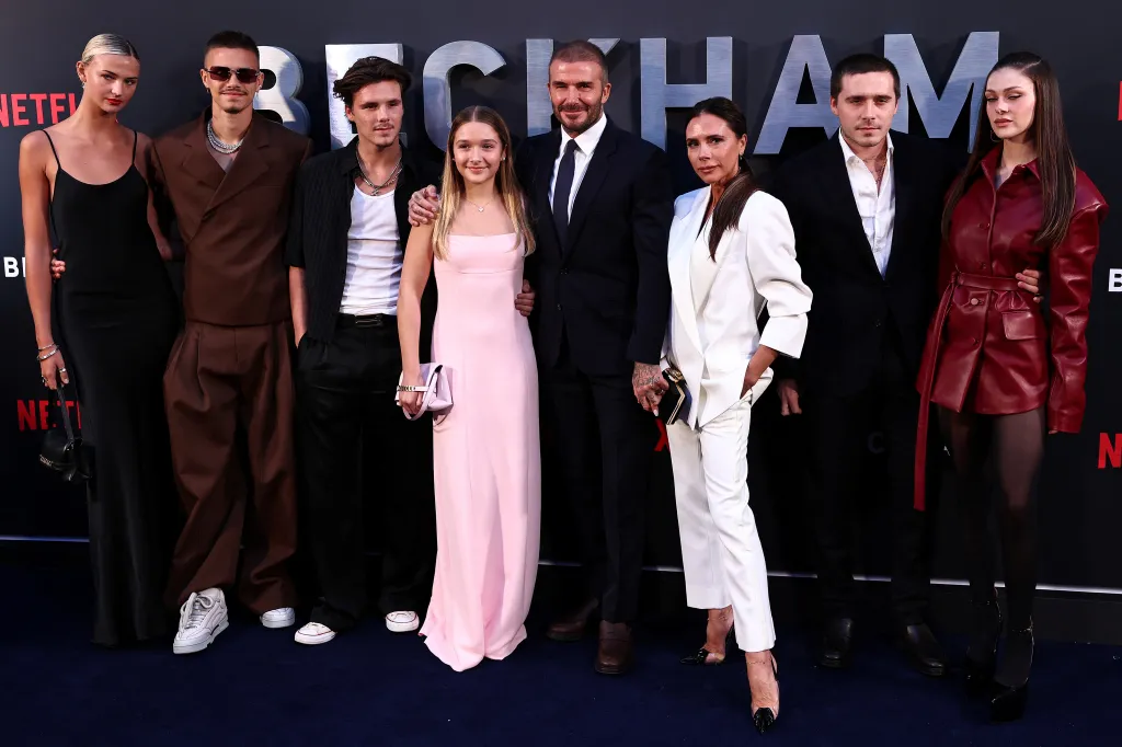 David and Victoria Beckham pose on a red carpet with their children and partners at the premiere of 