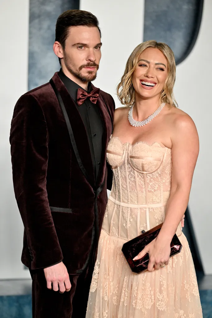 Matthew Koma in a velvet suit and Hilary Duff in a lace gown, at the 2023 Vanity Fair Oscar Party.