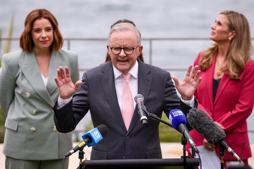 Australia's Prime Minister Anthony Albanese speaking at an official function regarding social media reform, with two women standing behind him.