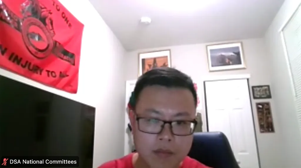 Anlin Wang from DSA's National Committees in a screen grab from a meeting, with a red flag hanging behind him.