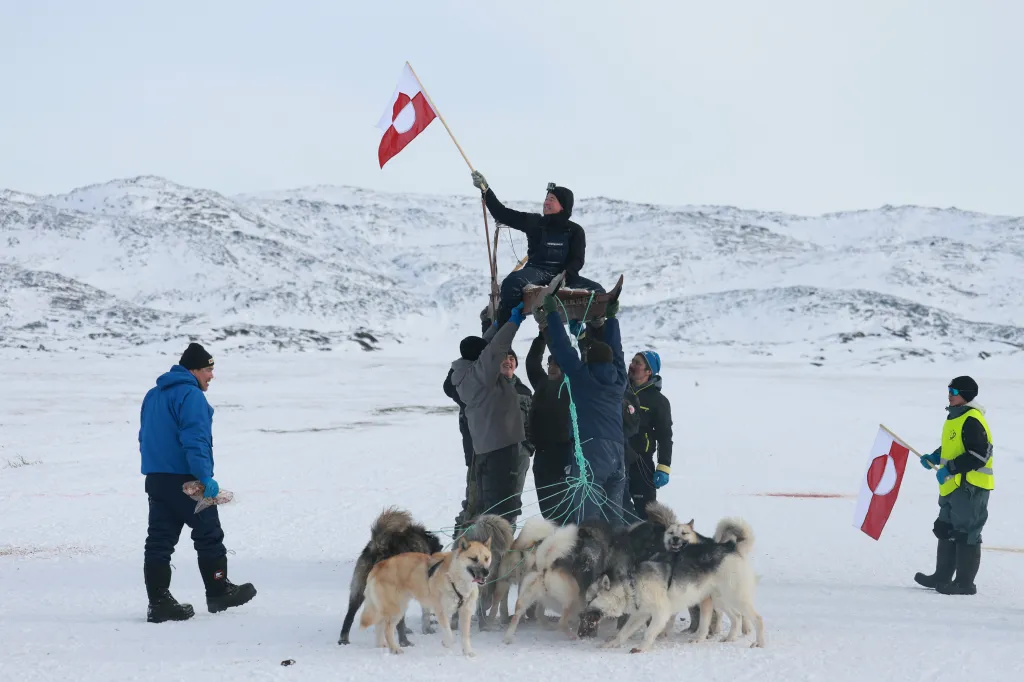 A musher celebrates after completing a dog sled race to determine which contestant attends the national competition on March 08, 2025, in Ilulissat, Greenland.