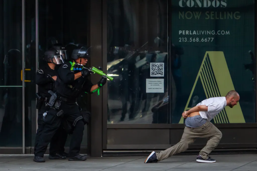Los Angeles police point a rubber bullet gun at a man during an anti-Trump protest.