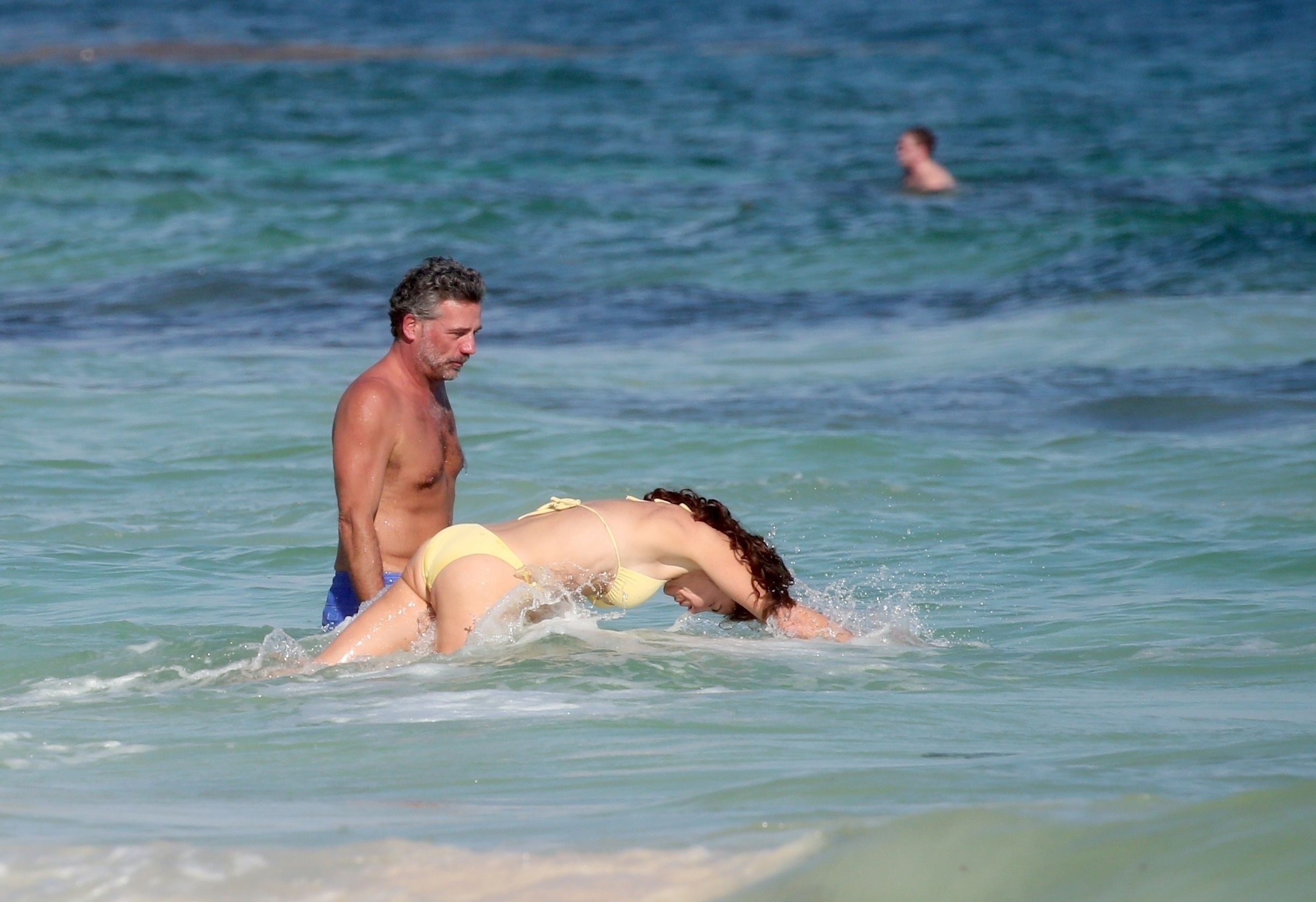 Luann De Lesseps in a yellow bikini splashing in the Caribbean Sea while Michael Riemerschmid watches her.