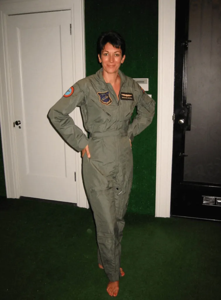 Ghislaine Maxwell in a gray jumpsuit, standing barefoot on green carpet.