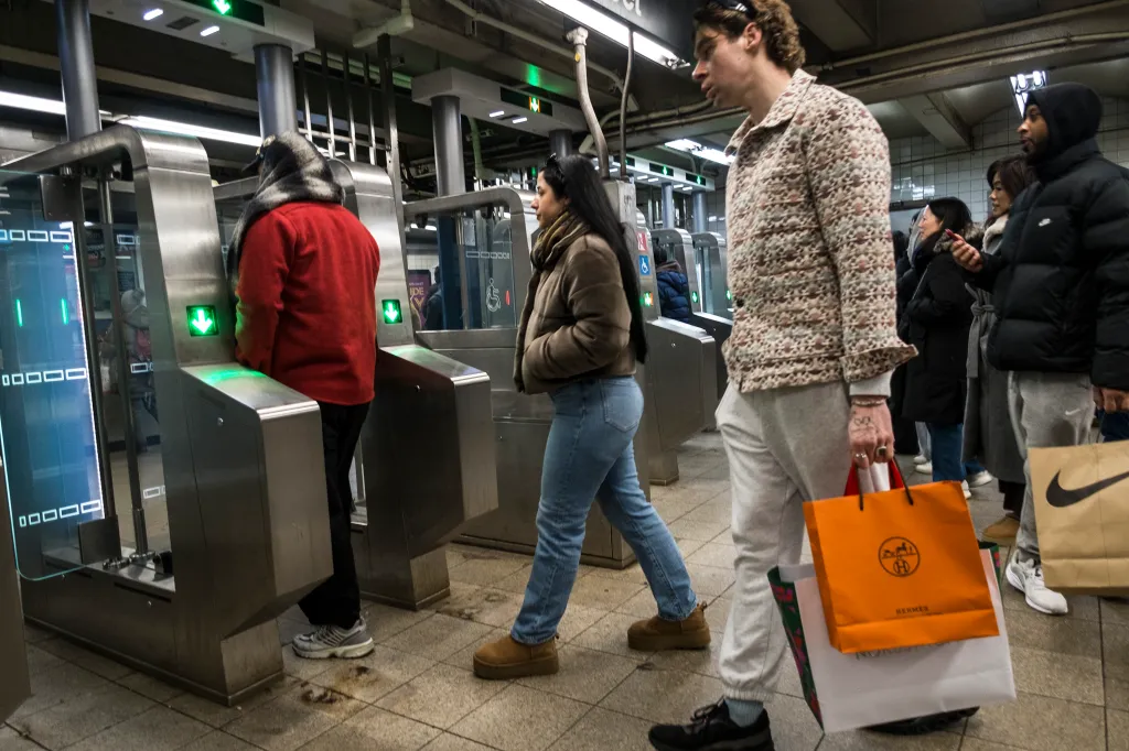 People use the new MTA fare gates at a subway station.