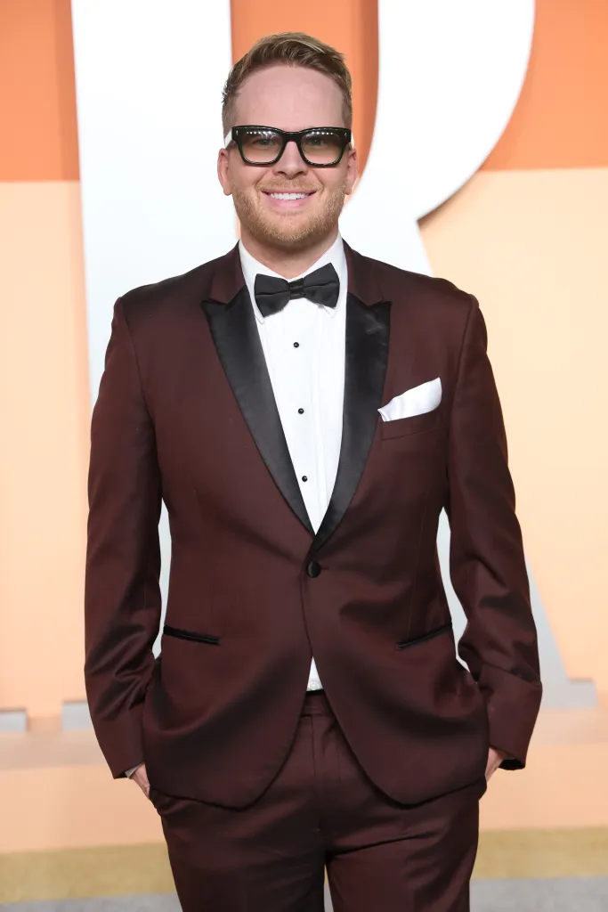 Michael Morriatti attends the 2025 Vanity Fair Oscar Party in a burgundy tuxedo with a black bow tie and glasses.