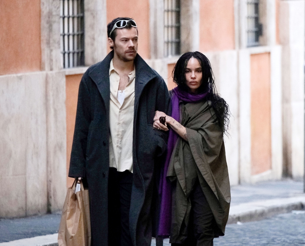 Harry Styles and Zoe Kravitz walking arm-in-arm down a street.